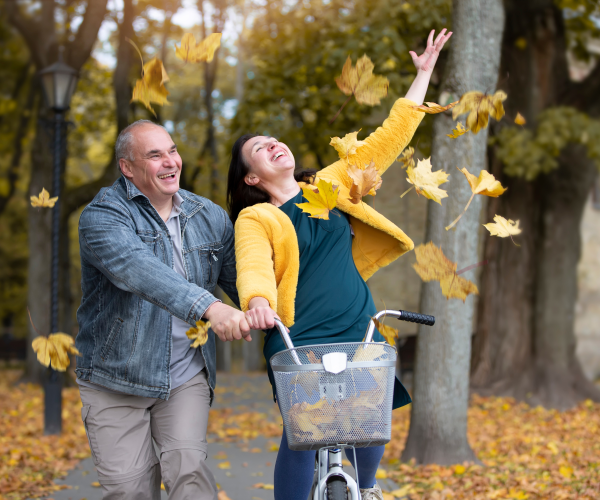 couple-riding-bike-through-autumn-foilage-2000x1500-1.png